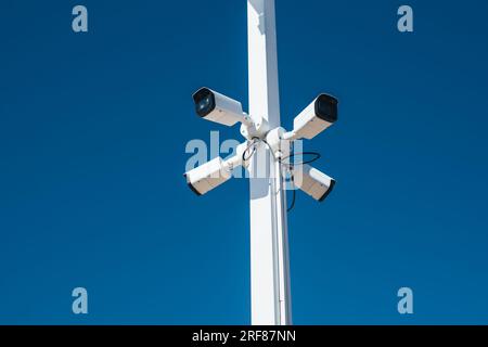 Security video cameras on a pole on blue sky background Stock Photo