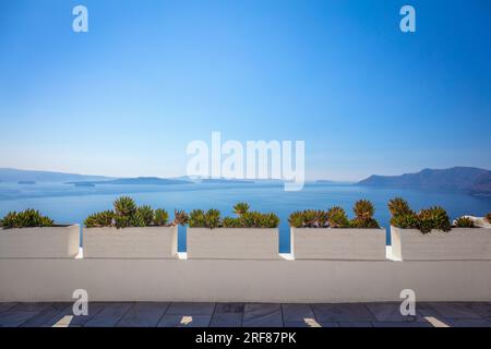 Conceptual background - Santorini. Greece, Santorini island, Oia - white architecture, flowers and blue sea and sky. Abstract background, empty space. Stock Photo