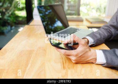Businessman using smart phone while conference. Businessmen discussing together in meeting room. Business team meeting and discussing project plan. Stock Photo
