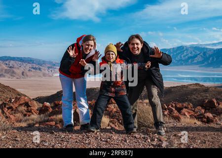 Father, mother and son happy family posing on mountains background at winter Stock Photo