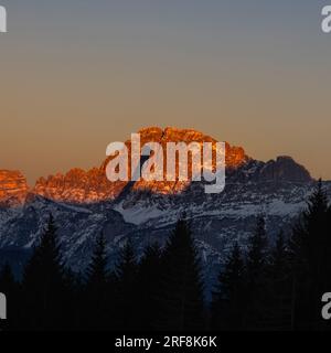 The peak of the mountains of the dolomites during sunset. High mountain landscape of the Dolomites in winter. Fantastic orange evening landscape shini Stock Photo