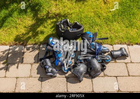 Close-up view of in lines and full protection accessories on ground. Active lifestyle concept. Stock Photo