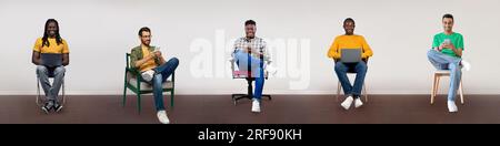 Five diverse men sitting on chairs and using different gadgets over light background, creative collage, panorama Stock Photo