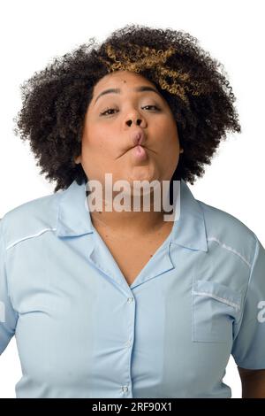 Waist up vertical portrait of happy young Afro-Latin female doctor in blue uniform, looking at camera, against white background. Stock Photo