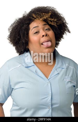 Waist up vertical portrait of happy young Afro-Latin female doctor in blue uniform, looking at camera, against white background. Stock Photo