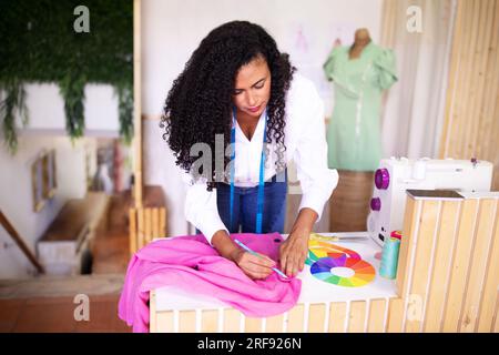 Seamstress lady adjusting garment for perfect fit in tailor atelier Stock Photo