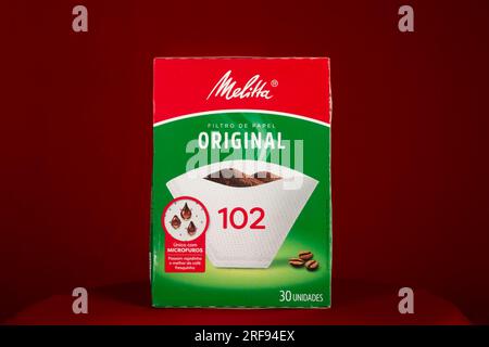 Salvador, Bahia, Brazil - July 30, 2023: Melitta brand paper filter packaging for straining coffee, isolated on a red background. Stock Photo