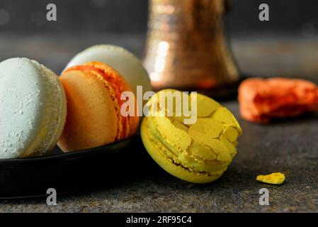 Plate with sweet macaroons on dark table Stock Photo