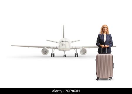 Full length portrait of a businesswoman with a suitcase in front of a plane isolated on white background Stock Photo