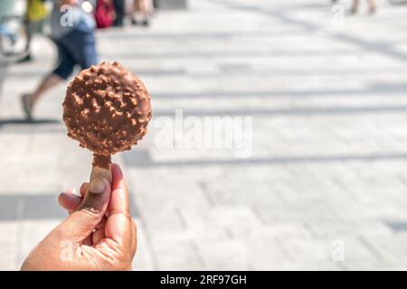 Choco-Hazelnut Bliss Classic milk chocolate ice cream. stock photos with a blurred public place as the background Stock Photo