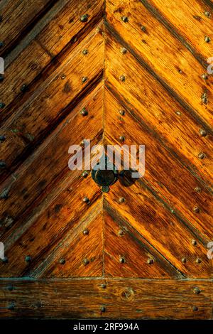 Old ancient colourful textured wood door. Vintage doorway. Old door handle. Background, pattern. Stock Photo