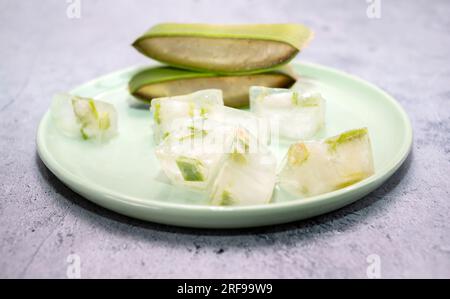 Closeup Aloe Vera Plant And Aloe Juice Ice Cubes On Green Plate On Table. Top View. Horizontal plane. Natural Homemade Cosmetics, DIY Concept. Food Stock Photo
