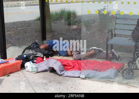 Homeless man sleeping in a bus shelter in Skokie, Illinois Stock Photo