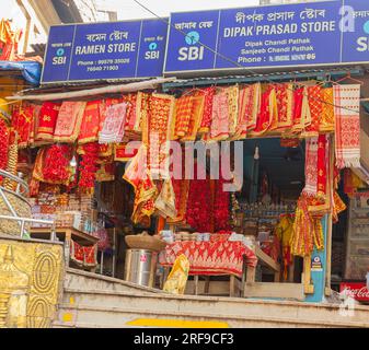 A shop selling Indian sweetmeats, garlands, tinselled headbands, scarves, and traditional Indian fabrics near the Kamakhya temple, Guwahati, Assam. Stock Photo