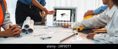 Engineer and architect working together brainstorming and designing blueprint using laptop working with architectural software for precise digital Stock Photo