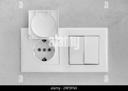 Closed socket and switch on porcelain stoneware in the bathroom Stock Photo