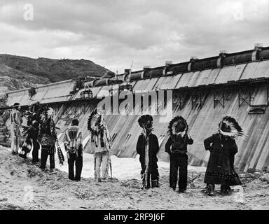 Grand Coulee Dam; Washington; c 1941  Native American watching the final stages of construction on the Grand Coulee Dam on the Columbia River, their traditional fishing ground, in Washington. It is the largest electric power producing facility in the US. It was built as part of the Works Progress Administration. Stock Photo