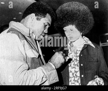 New York, New York  September 9, 1974 Muhammad Ali and Angela Davis exchange autographs when they run into each other at La Guardia Airport. Ali was on his way to Zaire to fight George Foreman, Stock Photo