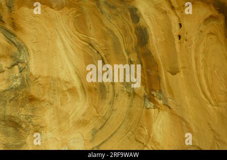Dark and light golden colored abstract swirls, beautiful background setting.  Colorful swirling pattern of gold, tan, brown color in unique design. Stock Photo