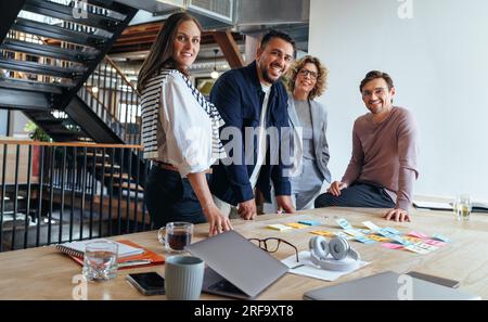 Group of marketing professionals having a meeting. Creative business team brainstorming with sticky notes. Happy business people putting their ideas t Stock Photo