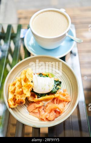 Potato waffles, Poached egg, avocado cream with salmon and egg . Healthy breakfast, protein. Restaurant dish.  Stock Photo