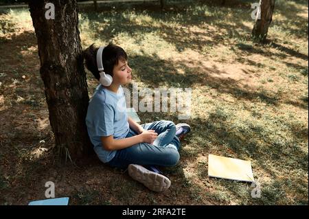 Teenage son listening music in headphones or playing online games ignoring  his mother Stock Photo - Alamy