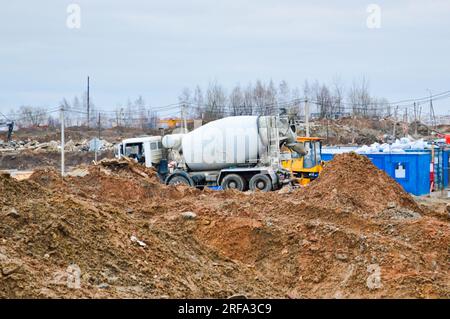 Large powerful truck concrete mixer at an industrial large construction site. Stock Photo