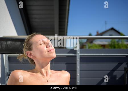 Close up of a pretty attractive woman enjoying the sun with her eyes closed Stock Photo