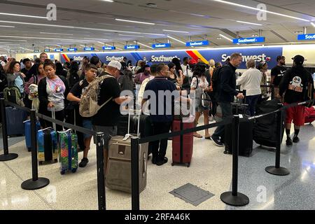 Passengers wait in line to check baggage at Southwest Airlines ticket counter at Los Angeles International Airport, Monday, July 31, 2023, in Los Angeles. Stock Photo