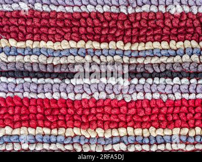 The detail of the linear patterns in a colorful woven fabric rug Stock Photo