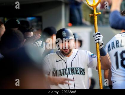 Seattle Mariners designated hitter Cal Raleigh holds a trident in the  dugout after hitting a home run against the Pittsburgh Pirates as teammates  throw sunflower seeds at him during the fourth inning