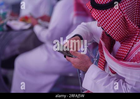 Saudi arab man Works on mobile phone reading or typing message Stock Photo