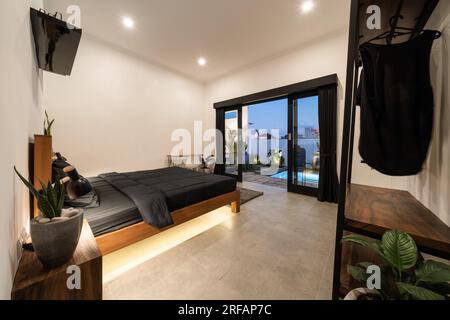 Luxury bedroom with modern wooden bed in loft style interior design room. Stock Photo