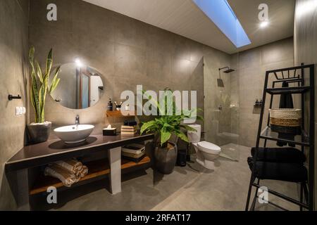 Luxury bathroom with polished concrete on the walls and PVC on the floor. Modern bathroom with cement polish walls. Stock Photo