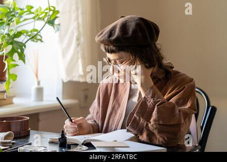 Pensive artist girl involving draw illustration in cozy home studio. Art, hobby, freelance concept Stock Photo