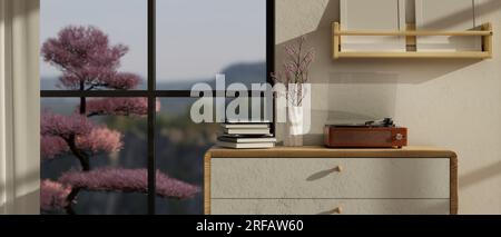 Close-up image of a vintage record player, books, and a flower vase on a minimal drawer against the window and wall in a beautiful minimal living room Stock Photo