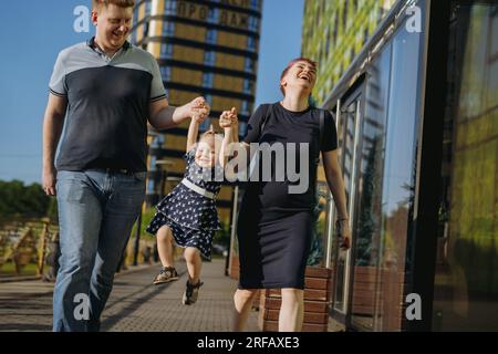 Happy caucasian family couple enjoy walking with daughter. mother happily laughing. High quality photo Stock Photo