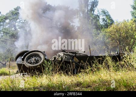 Historical reconstruction. An overturned and dirty German motorcycle between smoke and dust after a bomb explosion. Stock Photo