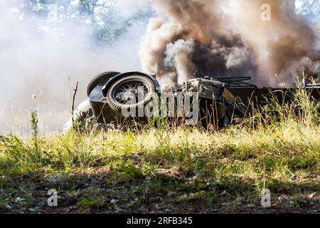 Historical reconstruction. An overturned and dirty German motorcycle between smoke and dust after a bomb explosion. Stock Photo