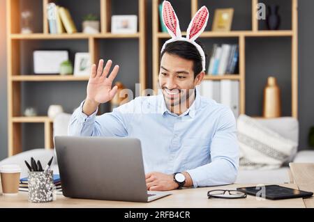 Easter bunny, ears and man on online meeting at home with computer screen and greeting. Remote work, holiday and rabbit costume in virtual call in Stock Photo