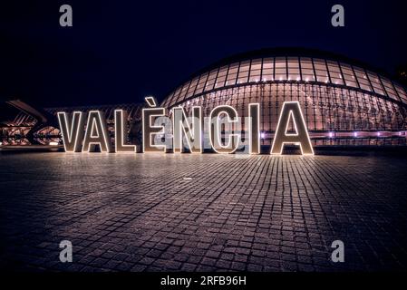 Illumianted Valencia neon sign in front of the Hemisferic building of the city of arts and sciences. Stock Photo