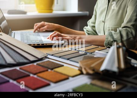 interior designer working on laptop in office. design material samples on desk Stock Photo