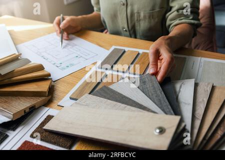 interior designer working on new house design project in office. choosing flooring and furniture materials and colors from samples Stock Photo
