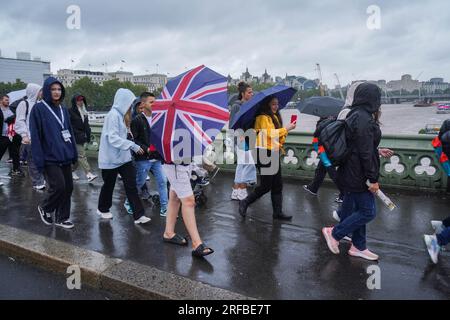 London UK. 2 August 2023   Pedestrians on Westminster bridge brave the lashing  rain and blustery conditions as the Met office issues yellow warnings  for strong winds in the UK. Credit amer ghazzal/Alamy Live News Stock Photo