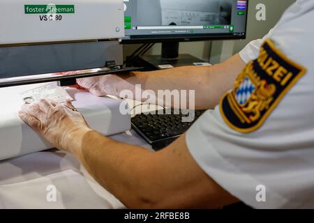 (dpa) - A police officer checks the I.D. card of a car driver on the ...