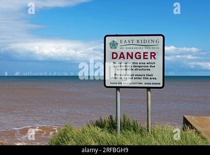 Warning Turrets Sign Erosion of Yorkshire coast UK at Kilnsea showing collapsed WW2 Gun ...