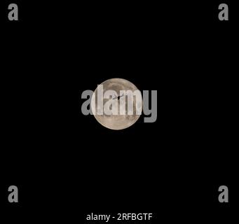 Super Moon, Plane Passing Over Moon Airplane passing the Super Moon Stock Photo