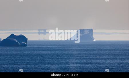 fata morgana effect in coastal arctic waters of greenland with distortion and inversion of icebergs Stock Photo