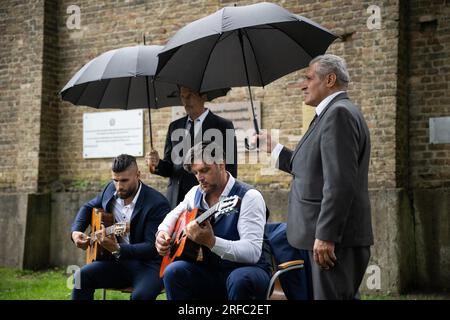 02 August 2023, Brandenburg, Fürstenberg/Havel: Marlon Reinhardt (from left) and Taylor Swing (from right) play guitar at the event for a new memorial plaque for Sinti and Roma in Ravensbrück . There is a new memorial plaque at the Ravensbrück Memorial for Sinti and Roma who were deported to the concentration camp during the Nazi era. Photo: Hannes P. Albert/dpa Stock Photo