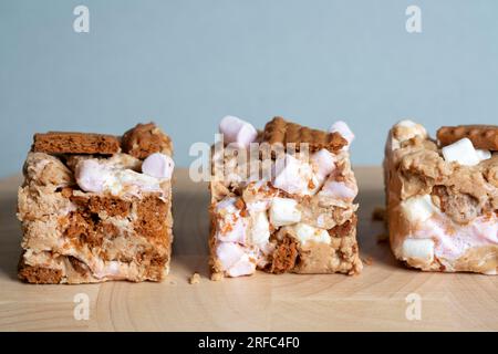 Portions or servings of Biscoff Rocy Road. An indulgent tasty Tiffin made with Biscoff spread, Biscoff biscuits, white chocolate and  marshmallows. Stock Photo